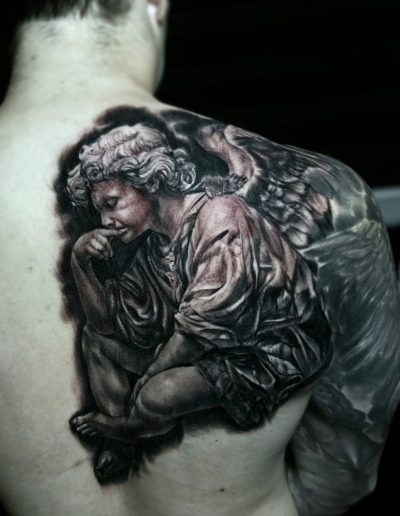Angel wings tattoo across upper back